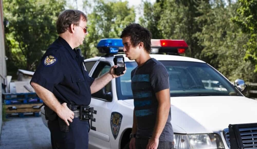 police officer administering a breathalyzer test