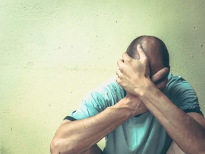 man covering his head and face